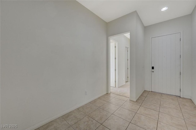 foyer featuring light tile patterned flooring and baseboards