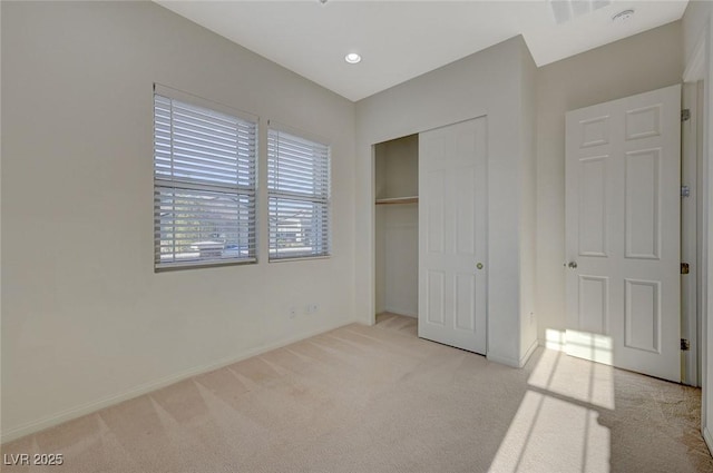 unfurnished bedroom featuring baseboards, visible vents, recessed lighting, a closet, and light carpet