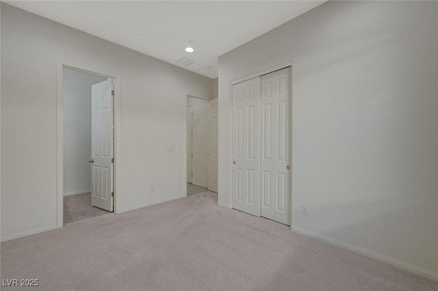 unfurnished bedroom with a closet, baseboards, and carpet floors