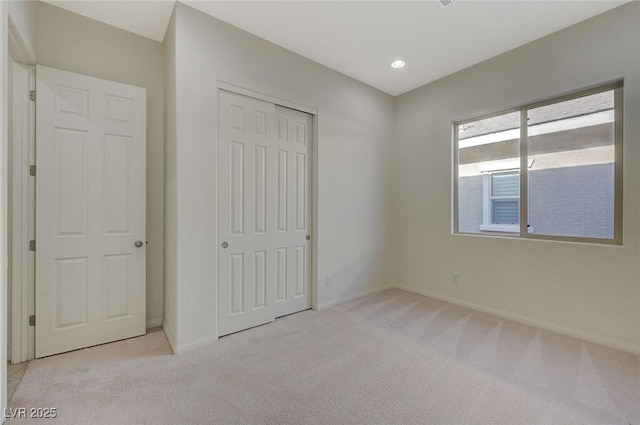 unfurnished bedroom featuring recessed lighting, baseboards, a closet, and carpet floors