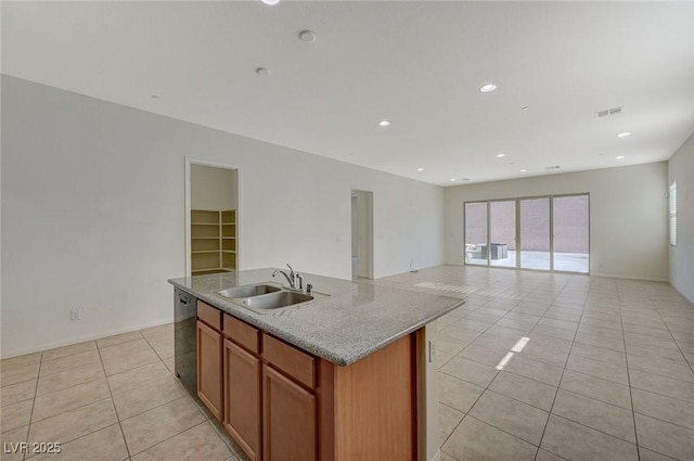 kitchen with visible vents, light tile patterned flooring, an island with sink, a sink, and black dishwasher