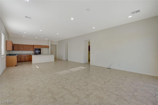 unfurnished living room with recessed lighting and visible vents