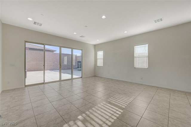 spare room with light tile patterned floors, recessed lighting, and visible vents