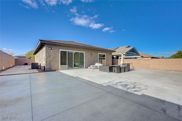 rear view of house featuring an outdoor living space, a fenced backyard, central AC, stucco siding, and a patio area