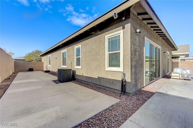 view of home's exterior with a patio area, stucco siding, cooling unit, and a fenced backyard