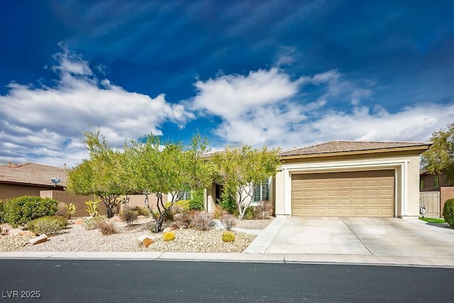 view of front facade with an attached garage, fence, driveway, and stucco siding