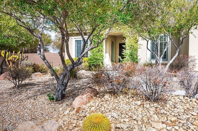 obstructed view of property featuring fence and stucco siding