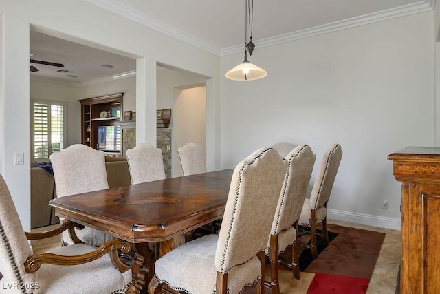 dining area with ceiling fan, baseboards, light tile patterned flooring, and crown molding