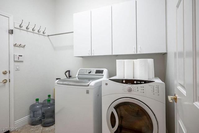 laundry room featuring washing machine and clothes dryer, cabinet space, and baseboards