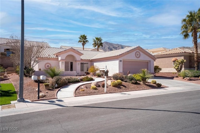 mediterranean / spanish-style house with a tiled roof, an attached garage, driveway, and stucco siding