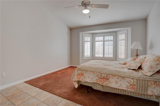 carpeted bedroom featuring tile patterned floors, ceiling fan, and baseboards