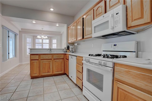 kitchen with white appliances, a peninsula, light tile patterned flooring, and light countertops