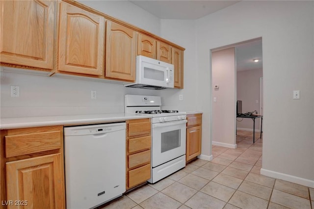 kitchen featuring white appliances, light tile patterned flooring, light brown cabinets, and light countertops