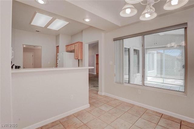 spare room featuring light tile patterned floors and baseboards