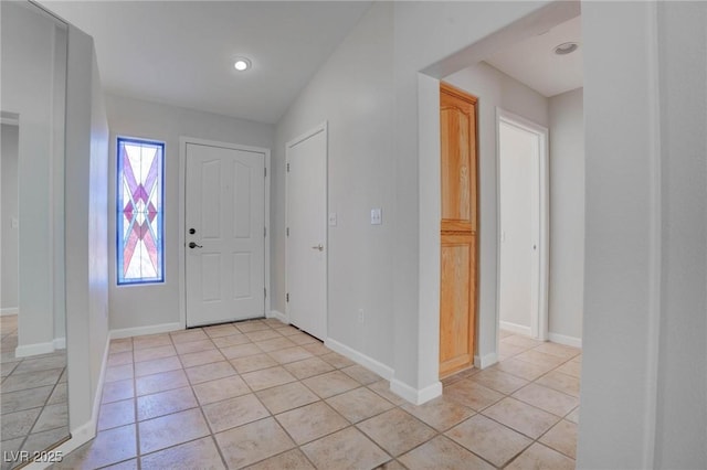 foyer with light tile patterned floors and baseboards