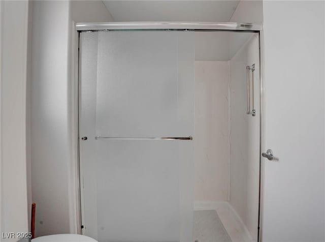 full bathroom with a shower stall and toilet