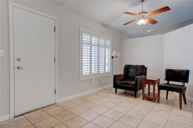 sitting room with light tile patterned floors, a ceiling fan, baseboards, and vaulted ceiling