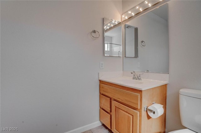 bathroom with tile patterned floors, toilet, vanity, and baseboards