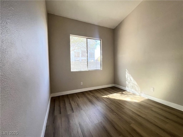 empty room with baseboards and wood finished floors