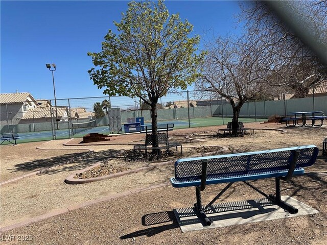 surrounding community featuring a tennis court and fence