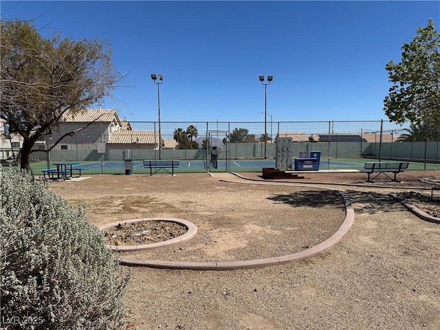 view of home's community featuring a tennis court and fence