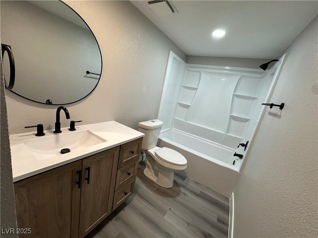 bathroom with visible vents, toilet, shower / bathtub combination, wood finished floors, and vanity