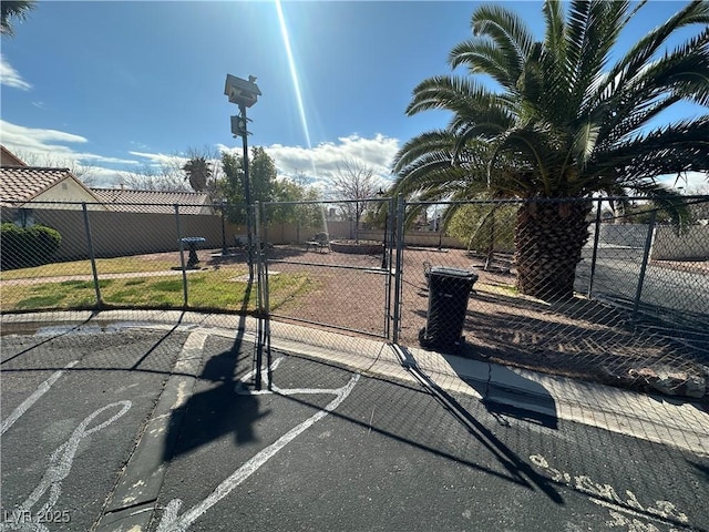 view of basketball court featuring a gate and fence