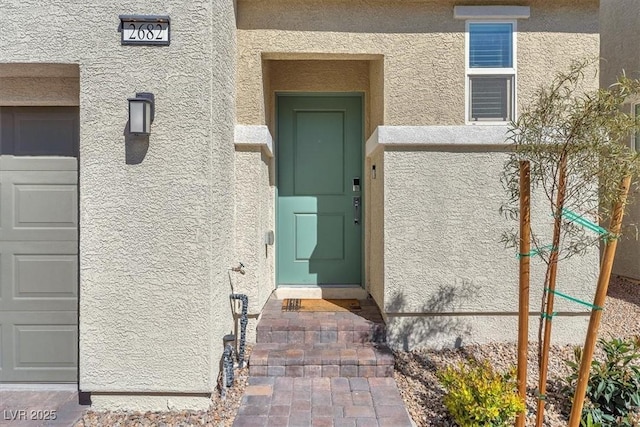 doorway to property featuring stucco siding