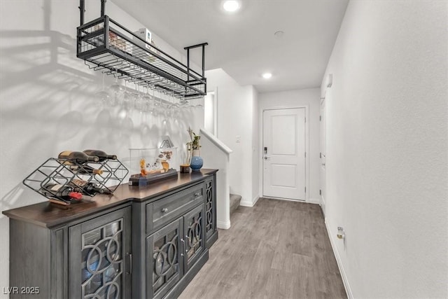 hall with recessed lighting, baseboards, wood finished floors, and stairs