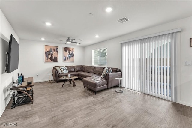 living area with recessed lighting, visible vents, baseboards, and wood finished floors