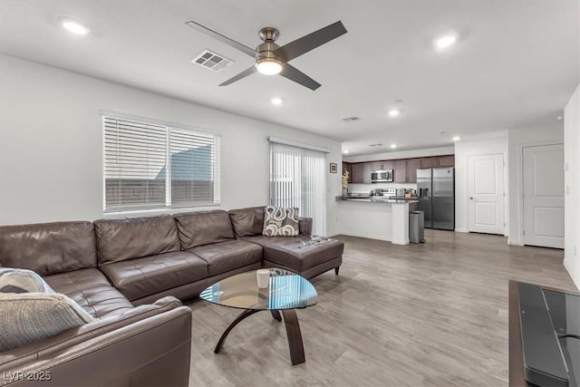 living room with recessed lighting, visible vents, light wood-style floors, and ceiling fan