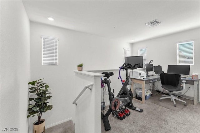 carpeted office space featuring visible vents and baseboards