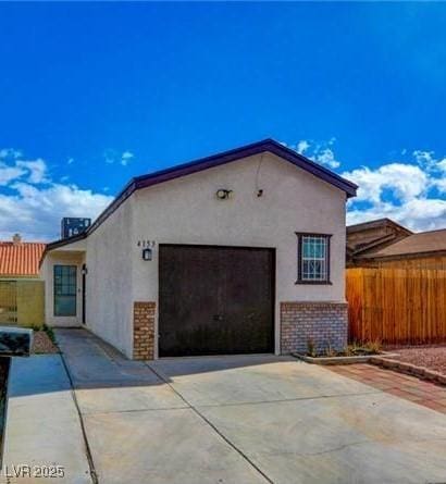 4153 Broadriver Dr, Las Vegas, NV 89108 - view of property exterior featuring an attached garage, driveway, stucco siding, and fence