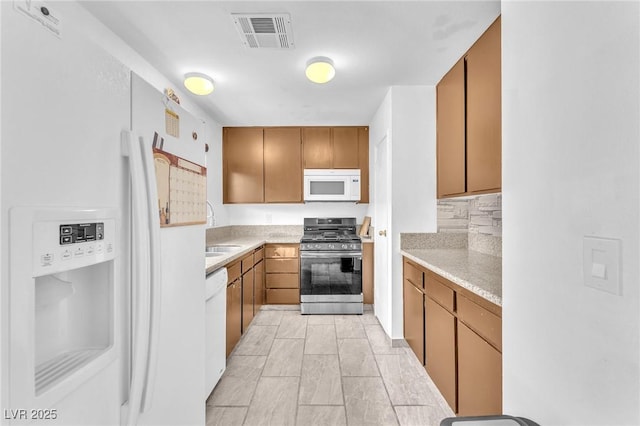 4153 Broadriver Dr, Las Vegas, NV 89108 - kitchen with visible vents, light countertops, white appliances, and a sink