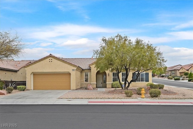 mediterranean / spanish-style home featuring concrete driveway, a tiled roof, a garage, and stucco siding