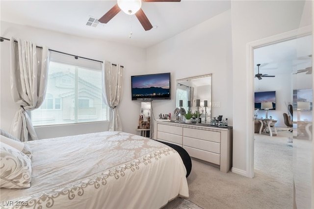 bedroom with baseboards, visible vents, ceiling fan, bar area, and light colored carpet