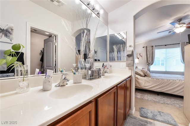 bathroom with visible vents, ensuite bath, a ceiling fan, and a sink