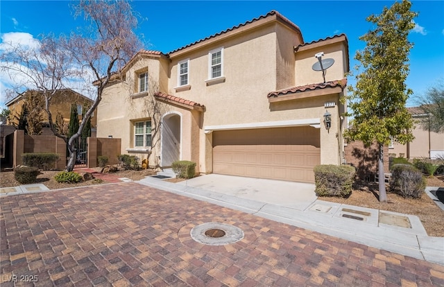 mediterranean / spanish-style home featuring a tile roof, stucco siding, driveway, and an attached garage