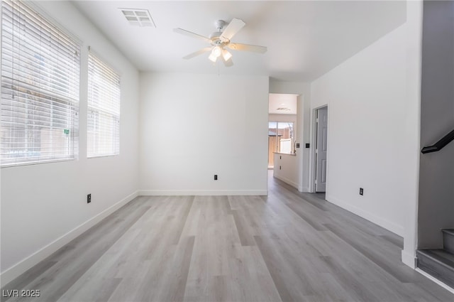 unfurnished living room featuring a ceiling fan, baseboards, visible vents, and light wood-type flooring