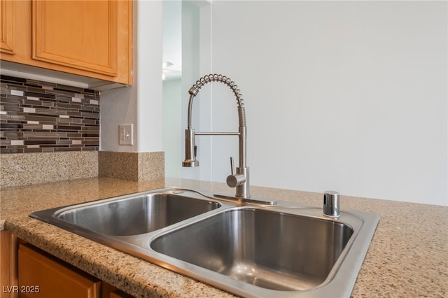 interior details with light countertops, backsplash, and a sink