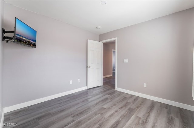 unfurnished bedroom featuring baseboards and wood finished floors