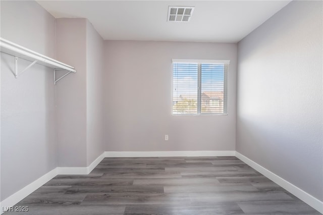 interior space with wood finished floors, visible vents, and baseboards