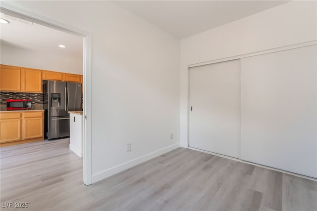 unfurnished dining area featuring recessed lighting, baseboards, and light wood-style flooring