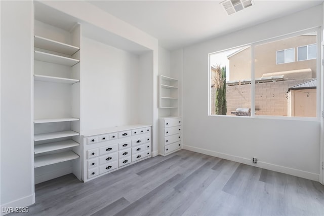 unfurnished bedroom featuring visible vents, baseboards, and wood finished floors