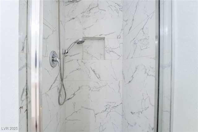 bathroom featuring a marble finish shower