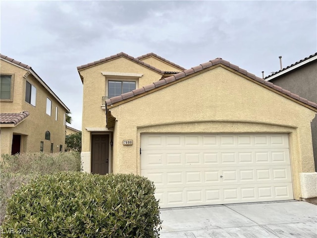 view of front of property featuring a tiled roof, stucco siding, an attached garage, and concrete driveway