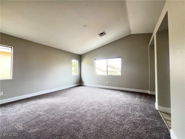 carpeted empty room featuring lofted ceiling, visible vents, and baseboards