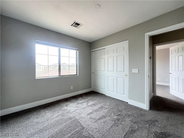 unfurnished bedroom featuring a closet, baseboards, visible vents, and carpet floors