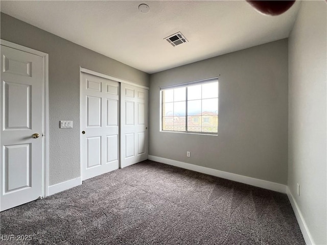 unfurnished bedroom featuring visible vents, baseboards, a closet, and carpet flooring