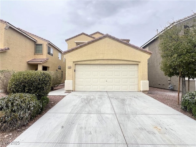 mediterranean / spanish home featuring a tiled roof, stucco siding, driveway, and an attached garage